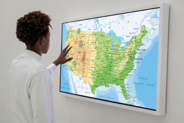 A person uses the interactive map on the board